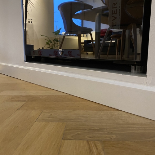 Fugearbejde ved fodlist langs glasvæg